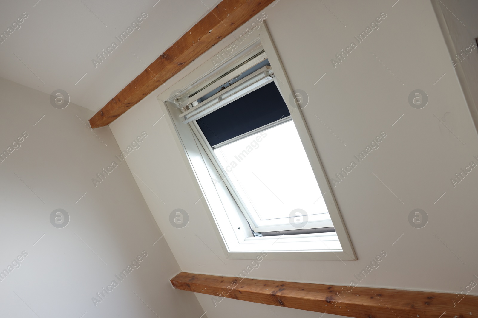 Photo of Roof window on slanted ceiling indoors, low angle view