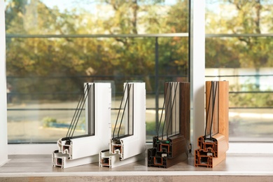 Photo of Samples of modern window profiles on sill indoors. Installation service