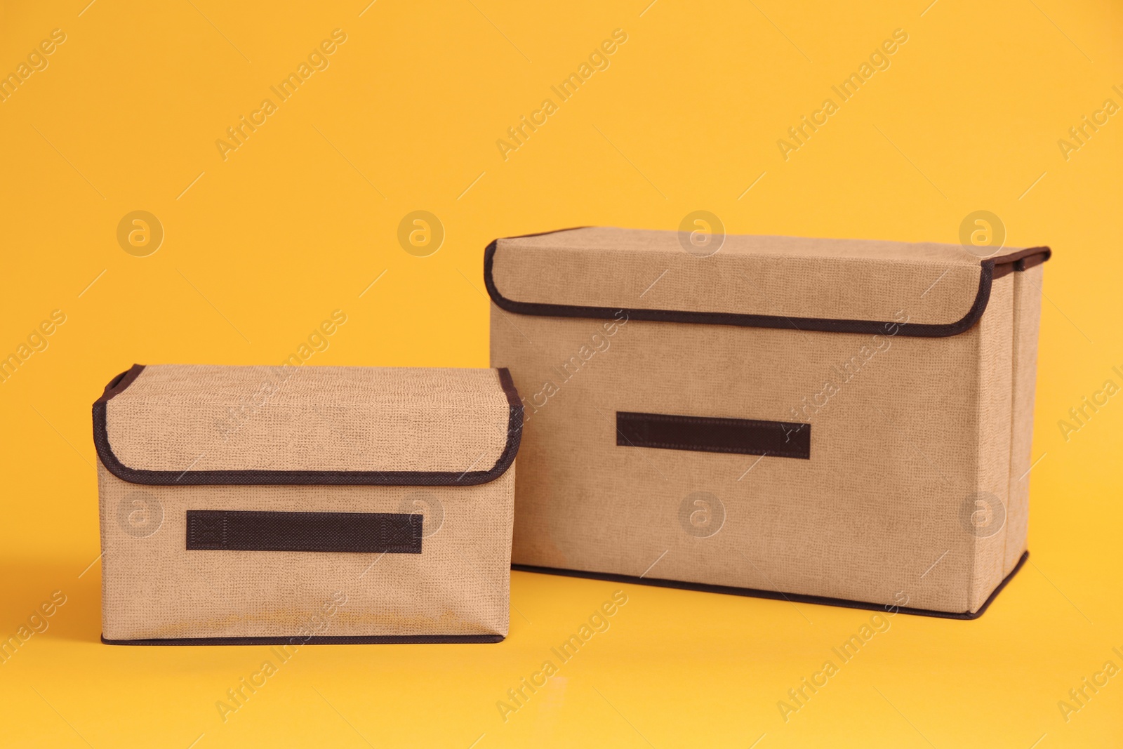 Photo of Two textile storage cases on yellow background