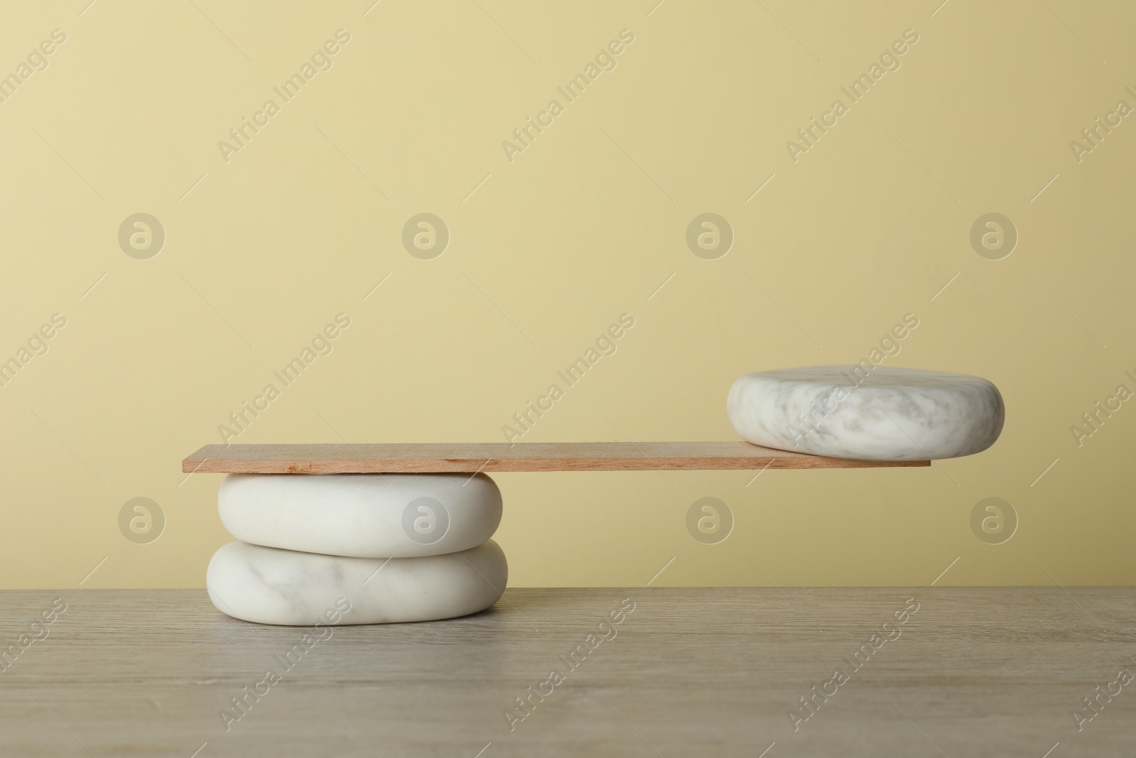 Photo of Stones with small wooden plank on table. Harmony and balance concept