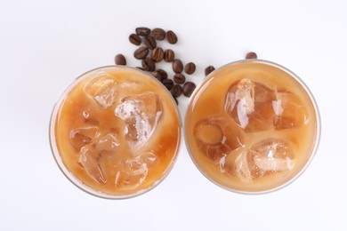 Photo of Glasses of iced coffee and beans on white background, top view