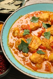 Photo of Delicious chicken curry with parsley on table, closeup