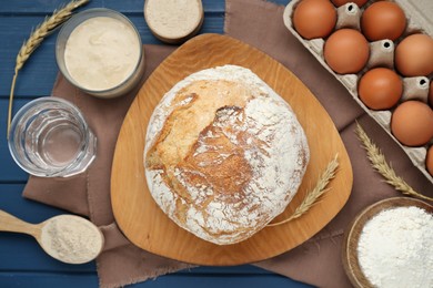 Flat lay composition with freshly baked bread and sourdough on blue wooden table