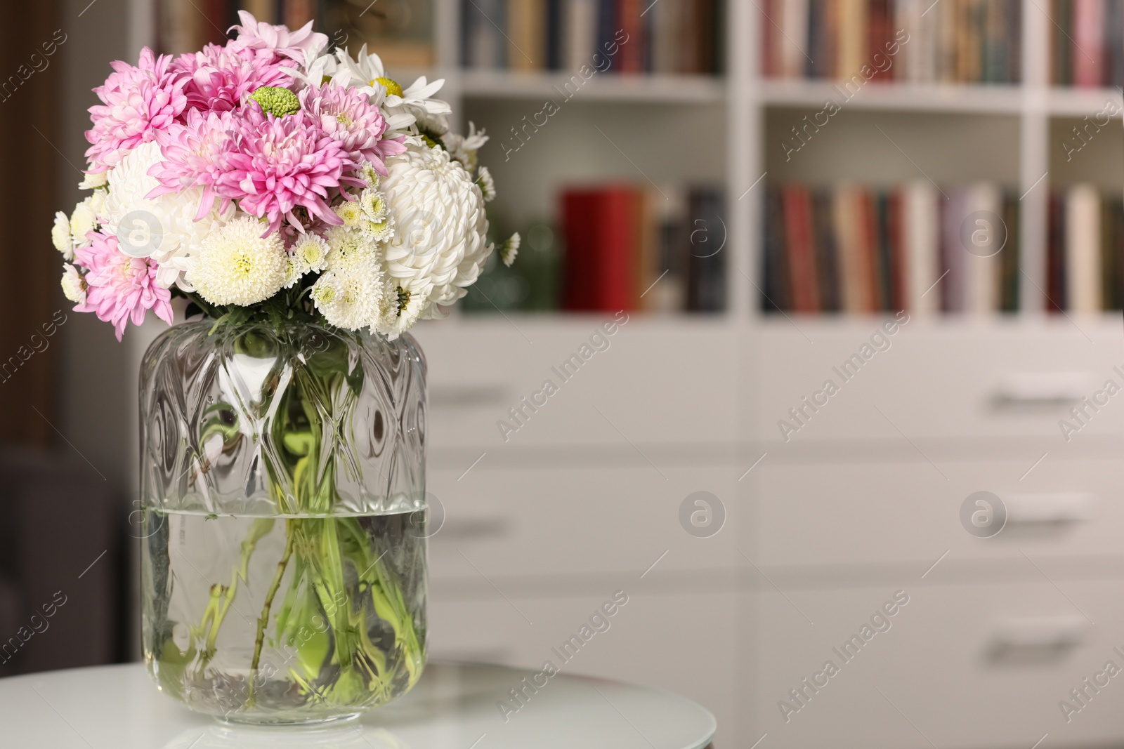 Photo of Bouquet of beautiful chrysanthemum flowers on white table indoors, space for text