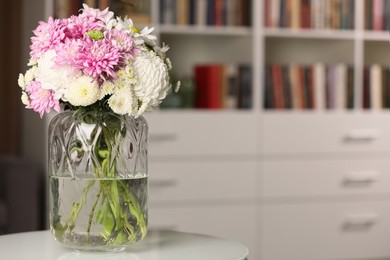 Photo of Bouquet of beautiful chrysanthemum flowers on white table indoors, space for text