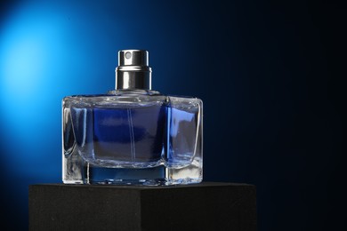 Photo of Luxury men`s perfume in bottle against dark background, space for text