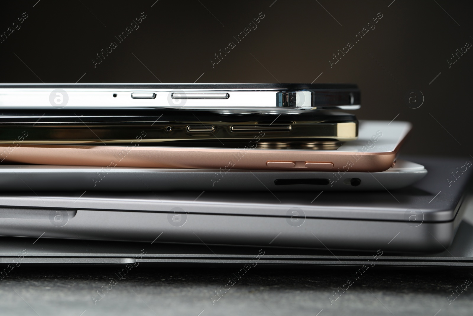 Photo of Stack of electronic devices on grey table, closeup