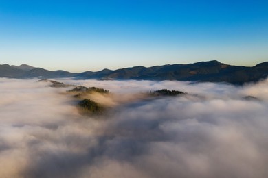Image of Beautiful landscape with thick mist in mountains. Drone photography
