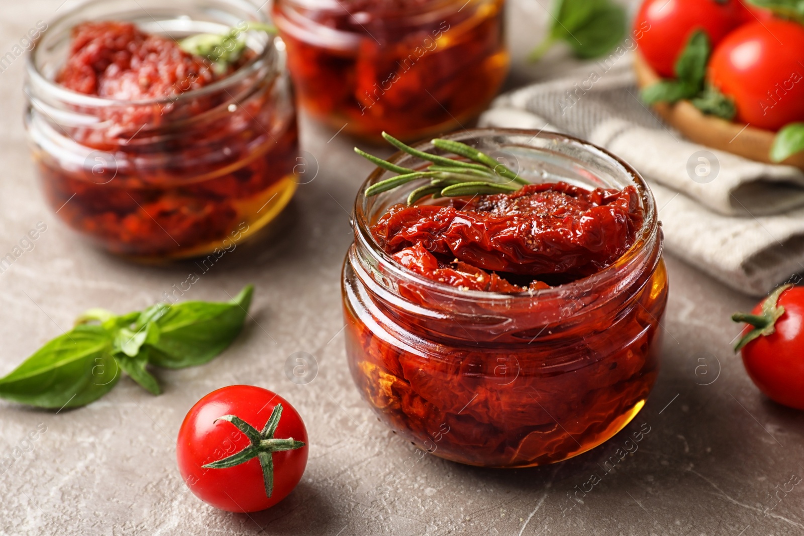 Photo of Dried tomatoes in glass jar on table. Healthy snack