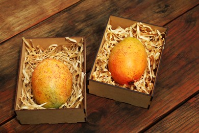 Delicious ripe juicy mangos on wooden table