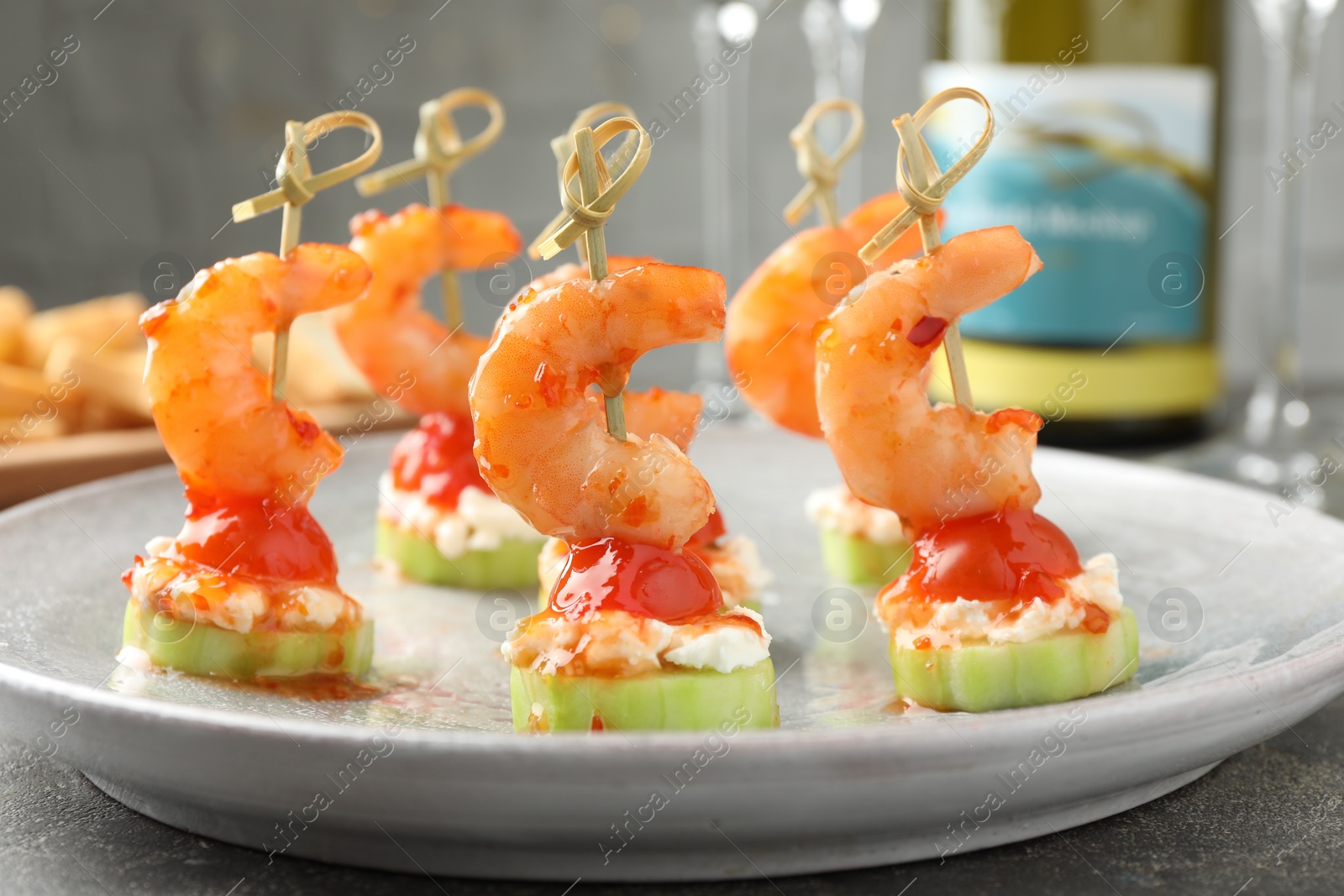 Photo of Tasty canapes with shrimps, vegetables and cream cheese on grey table, closeup