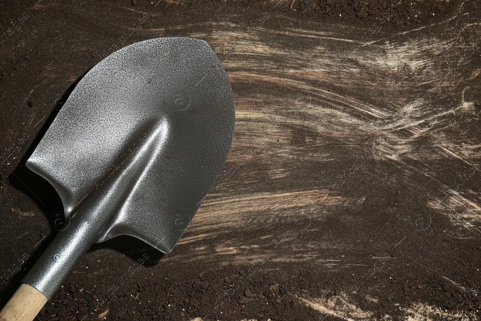 Metal shovel on dirty wooden surface, top view. Space for text Photo of Metal shovel on dirty wooden surface, top view. Space for text