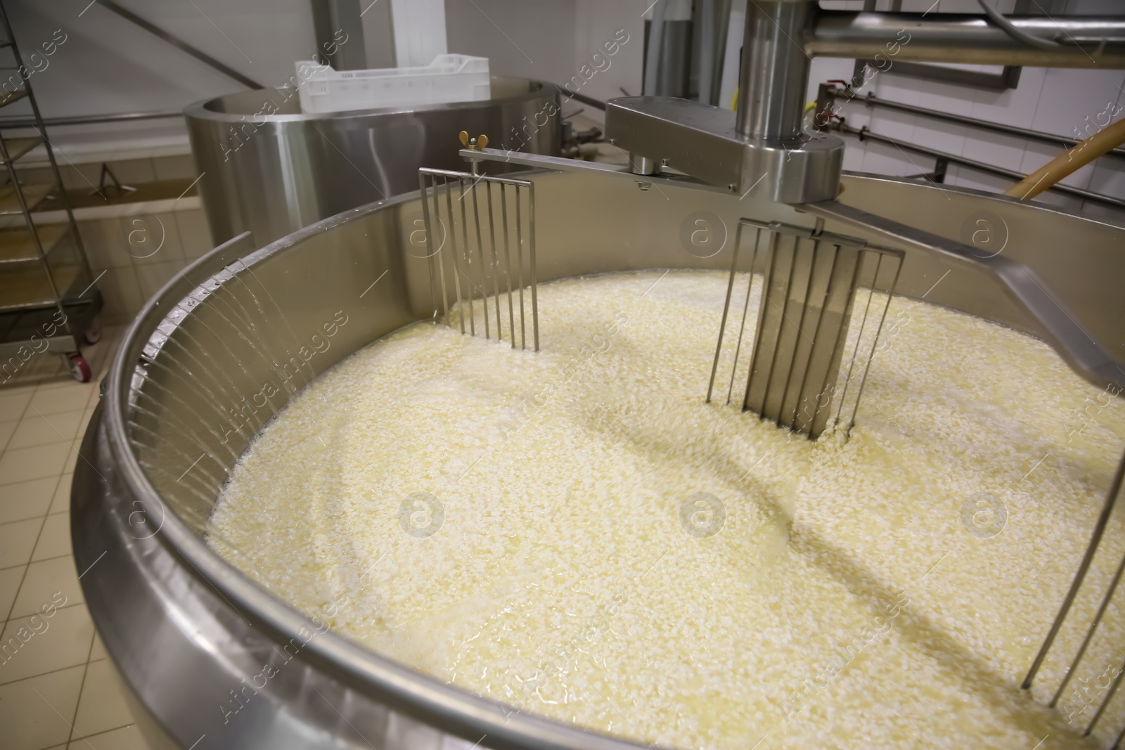 Photo of Adding water to curd and whey in tank at cheese factory