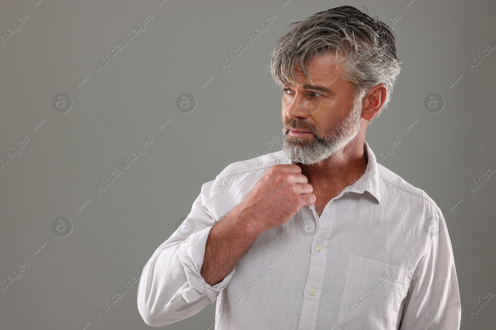 Photo of Portrait of confident man with beautiful hairstyle on light grey background. Space for text