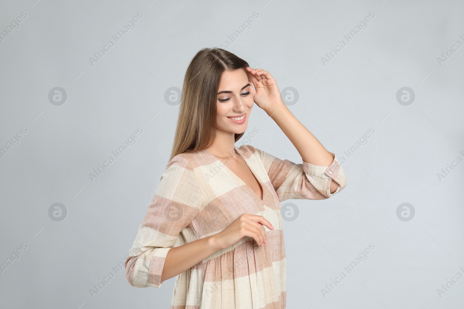 Photo of Young woman wearing stylish dress on light grey background