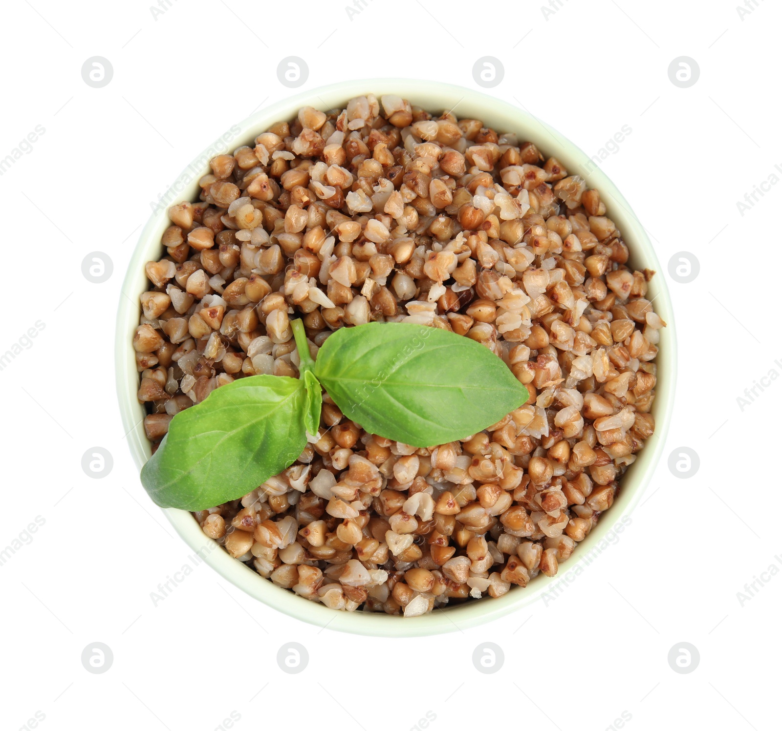 Photo of Bowl of buckwheat porridge with basil isolated on white, top view