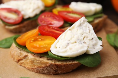 Photo of Delicious sandwich with burrata cheese and tomatoes on board, closeup