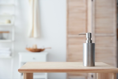 Photo of Soap dispenser on table against blurred background