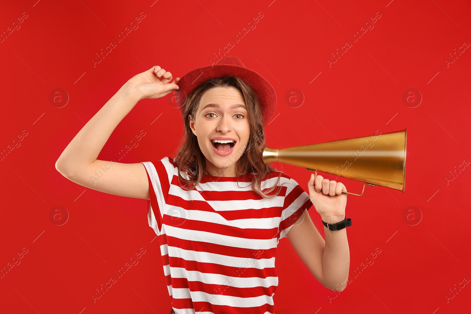 Photo of Young woman with megaphone on red background