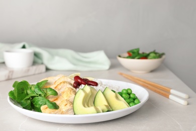 Photo of Plate of boiled rice with vegetables and meat on table. Space for text