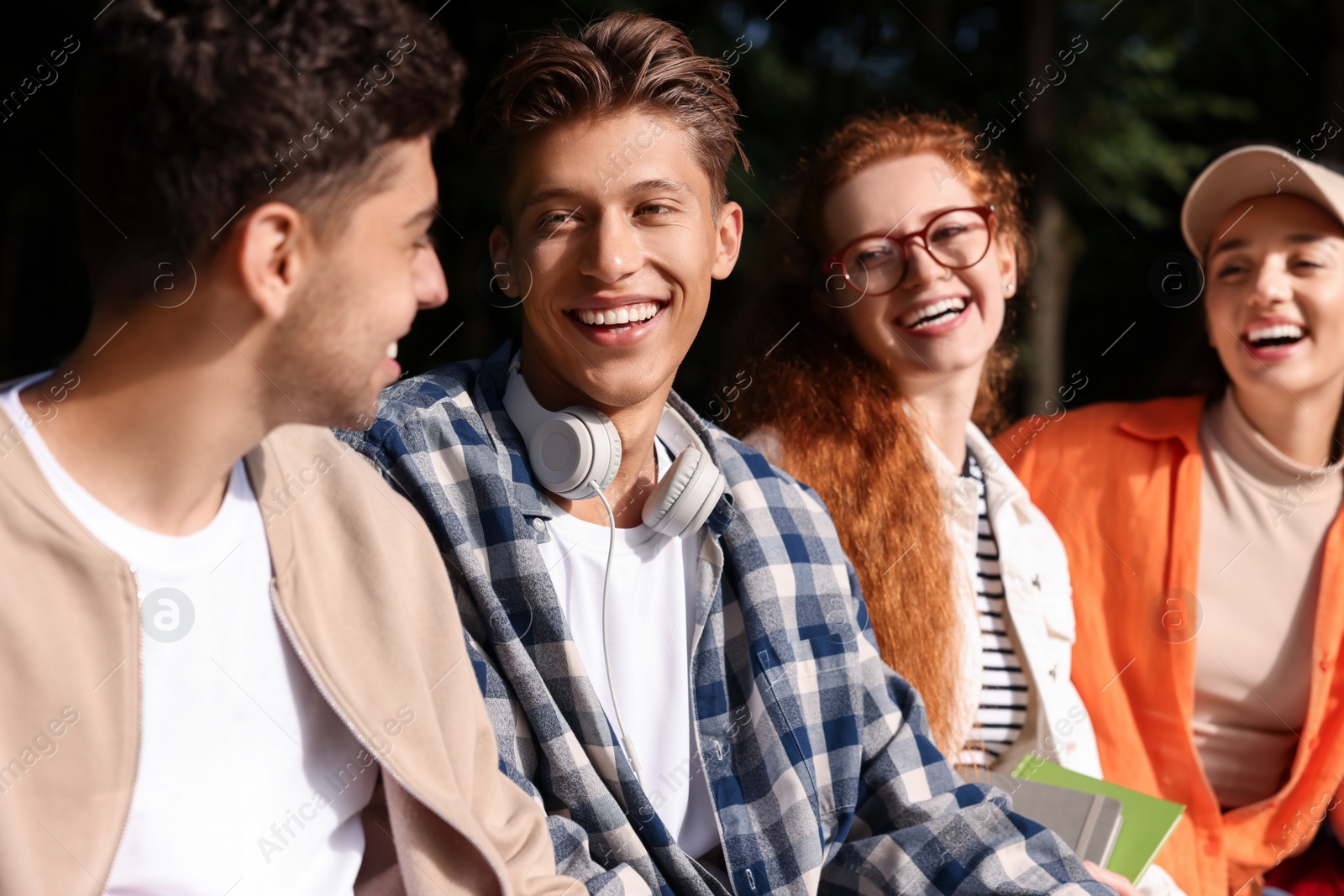 Photo of Group of happy young students having fun together in park