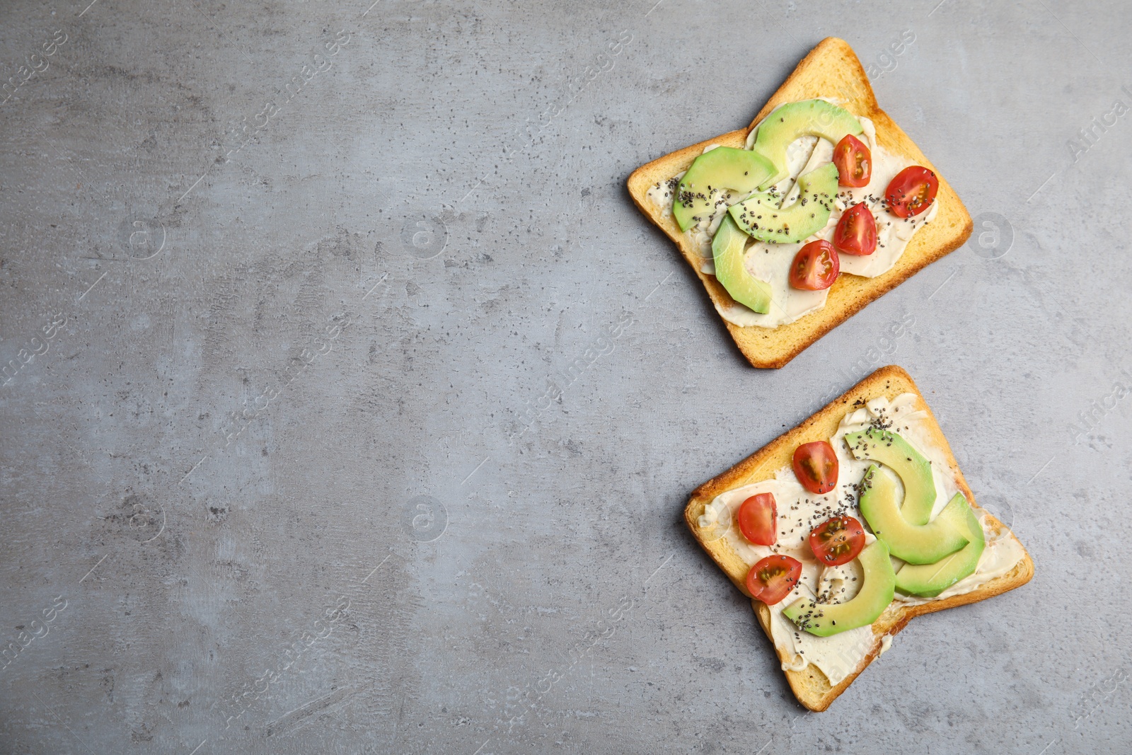 Photo of Tasty toasts with avocado, cherry tomatoes and chia seeds on grey background, top view. Space for text