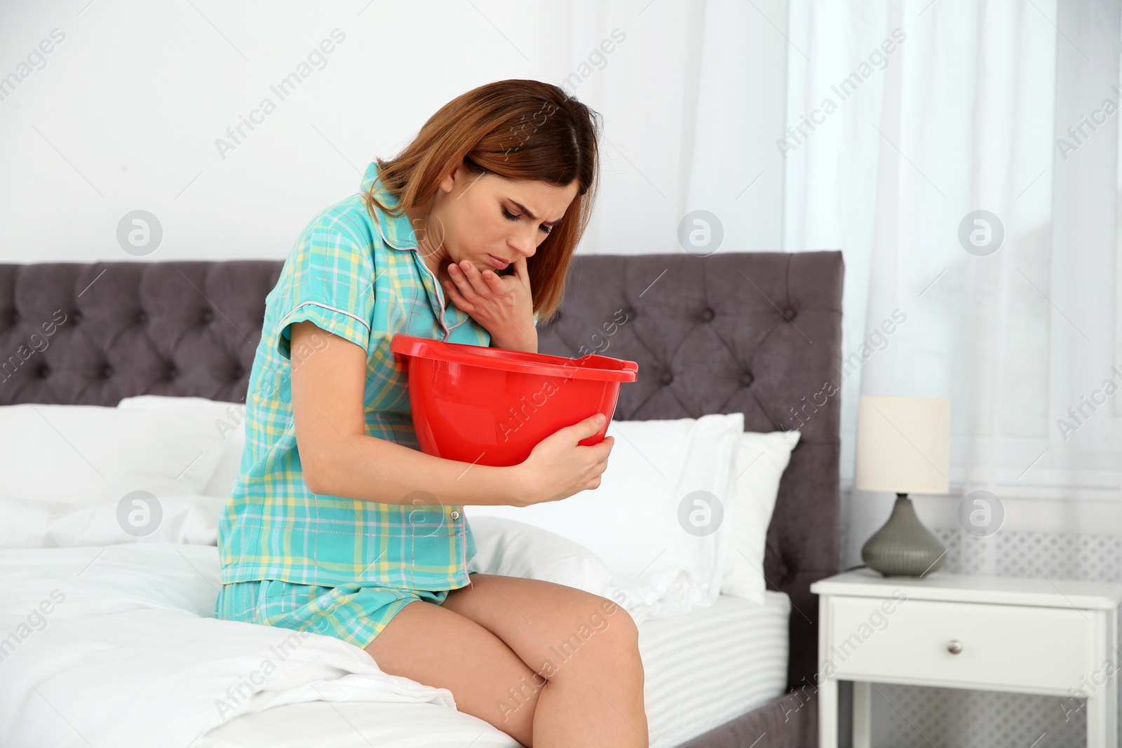 Photo of Young pregnant woman suffering from morning sickness at home. Space for text