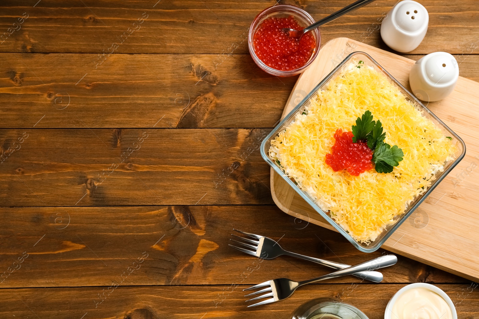 Photo of Traditional russian salad Mimosa served on wooden table, flat lay. Space for text