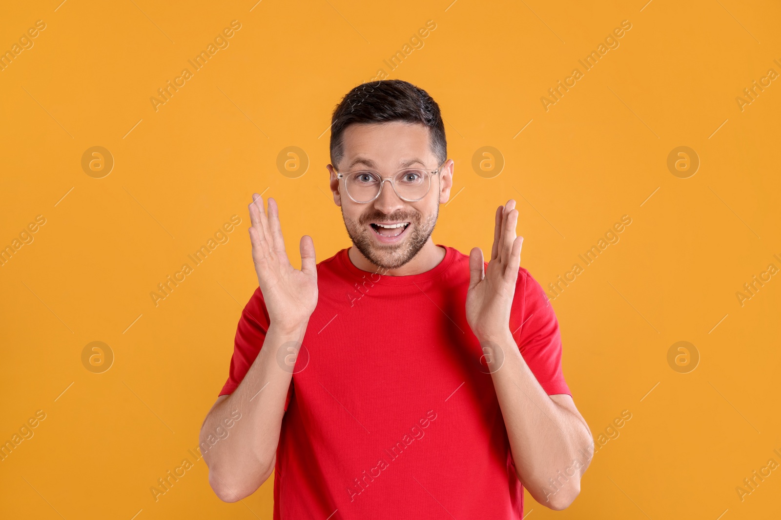 Photo of Portrait of emotional man in stylish glasses on yellow background