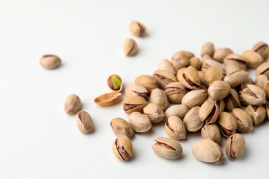 Pile of pistachio nuts on white background