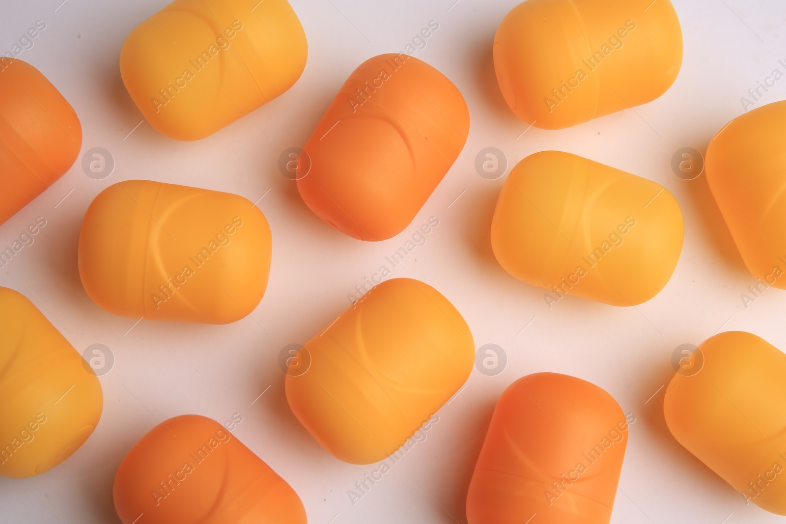 Photo of Sveti Vlas, Bulgaria - June 30, , 2023: Orange plastic capsules from Kinder Surprise Eggs on white background, flat lay