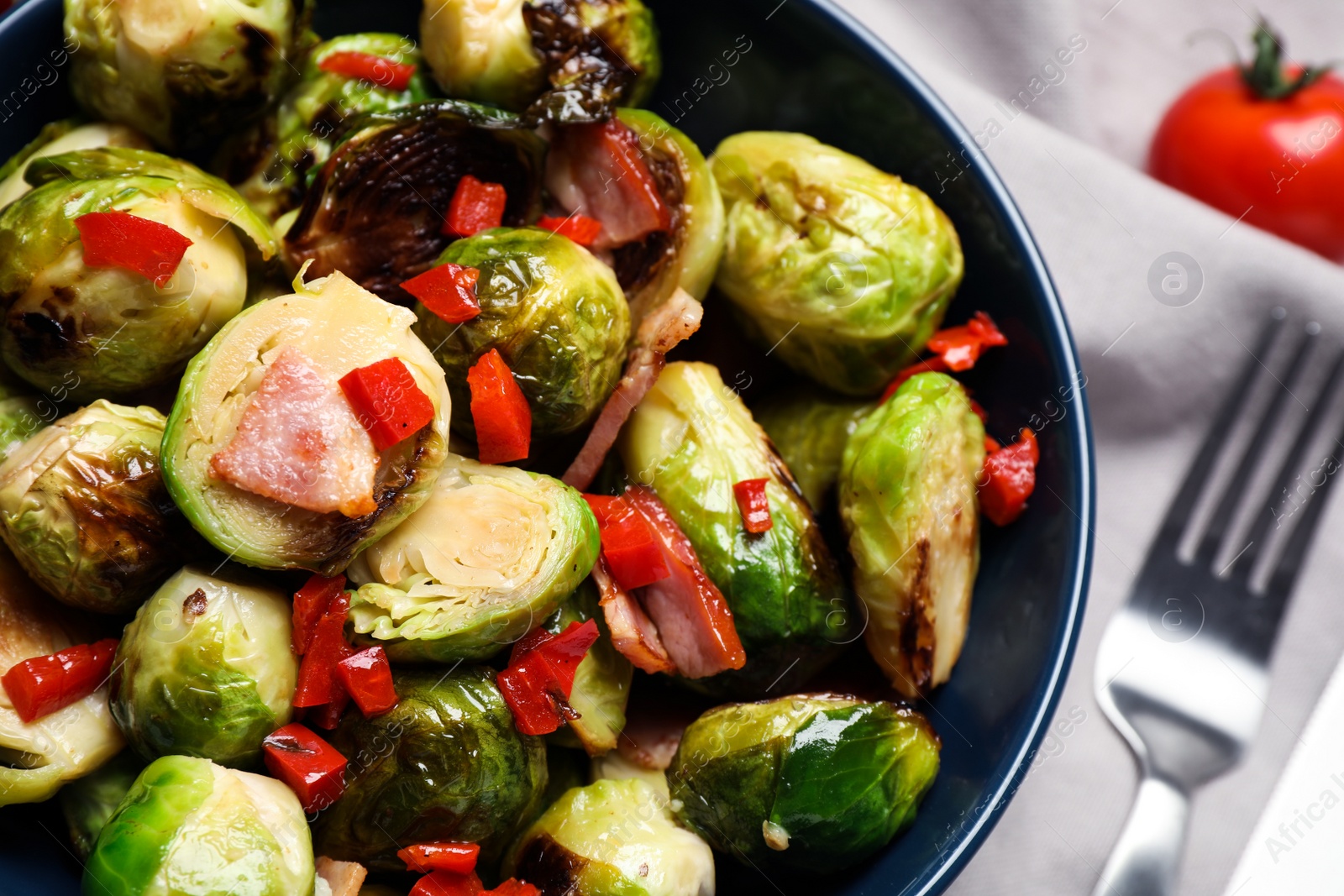 Photo of Delicious Brussels sprouts with bacon in bowl, closeup