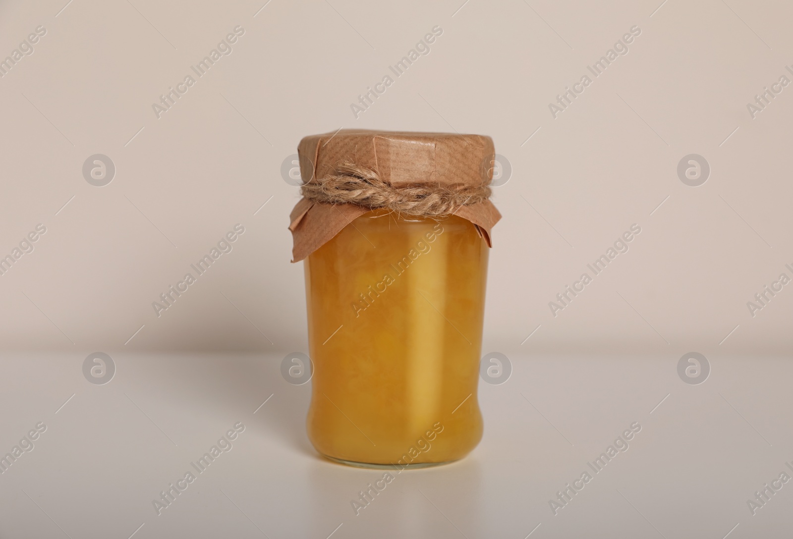 Photo of Tasty canned pineapple jam on white background