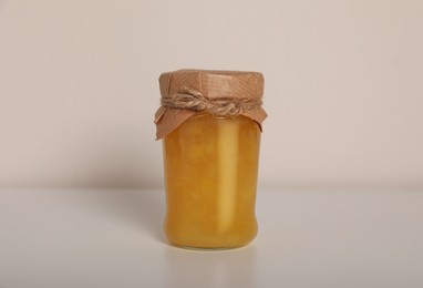 Photo of Tasty canned pineapple jam on white background