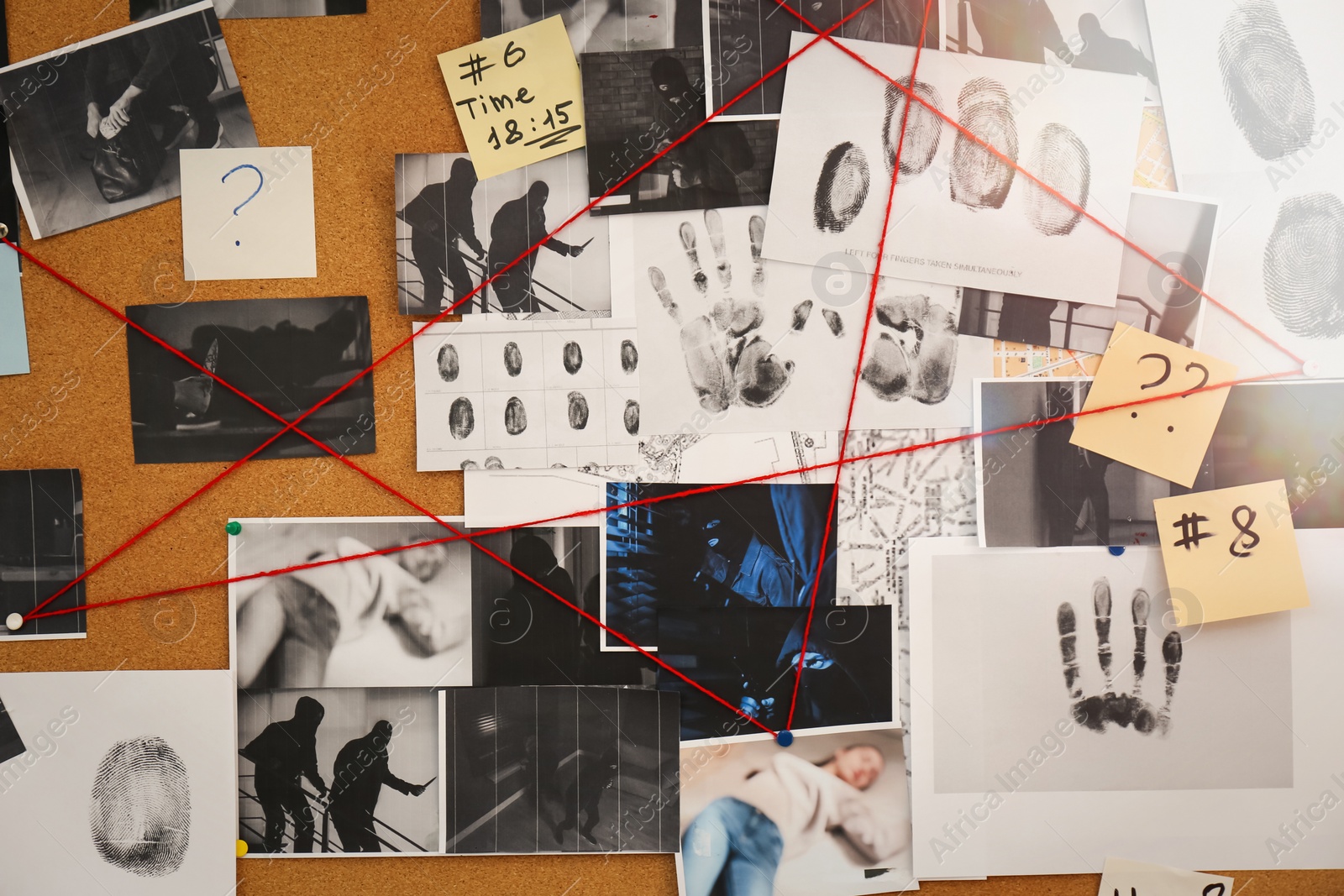 Photo of Detective board with crime scene photos, stickers, clues and red thread, closeup