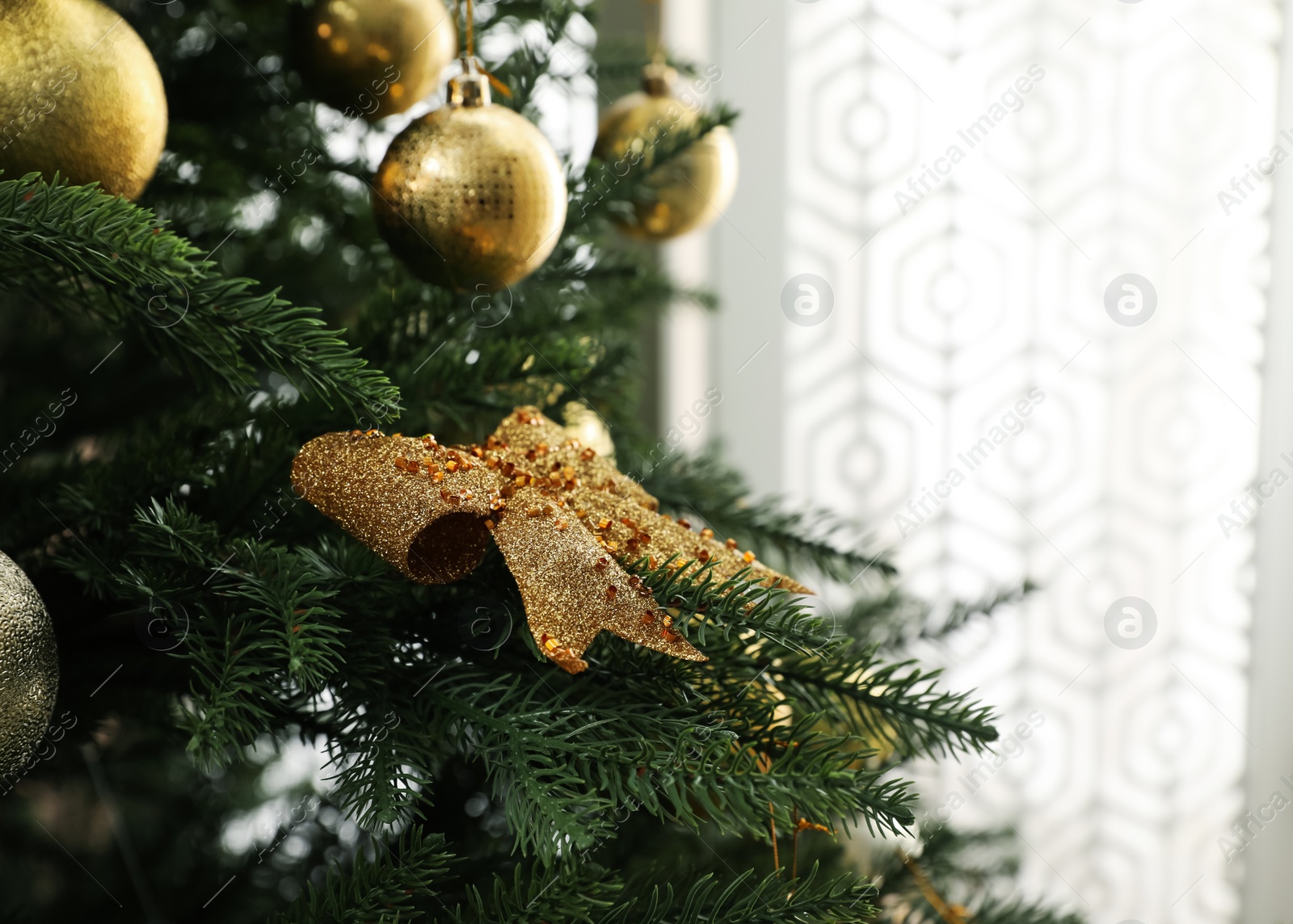Photo of Beautifully decorated Christmas tree in room, closeup. Space for text