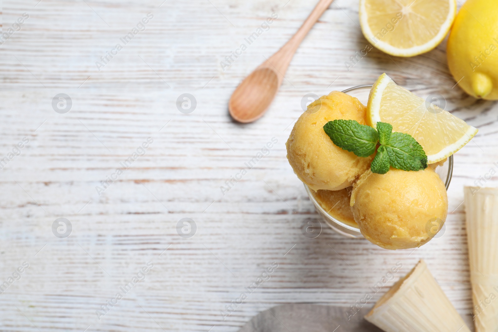 Photo of Yummy lemon ice cream served on white wooden table, flat lay. Space for text