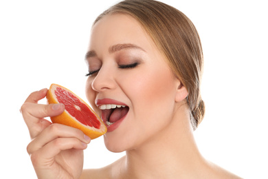 Young woman with cut grapefruit on white background. Vitamin rich food