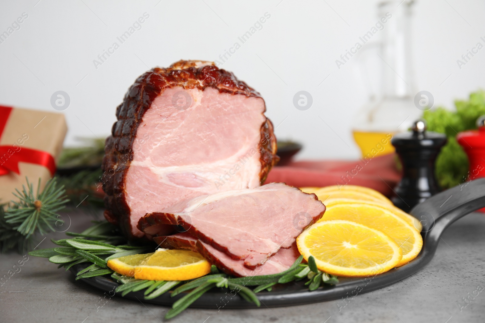 Photo of Delicious ham served with orange and rosemary on grey table. Christmas dinner