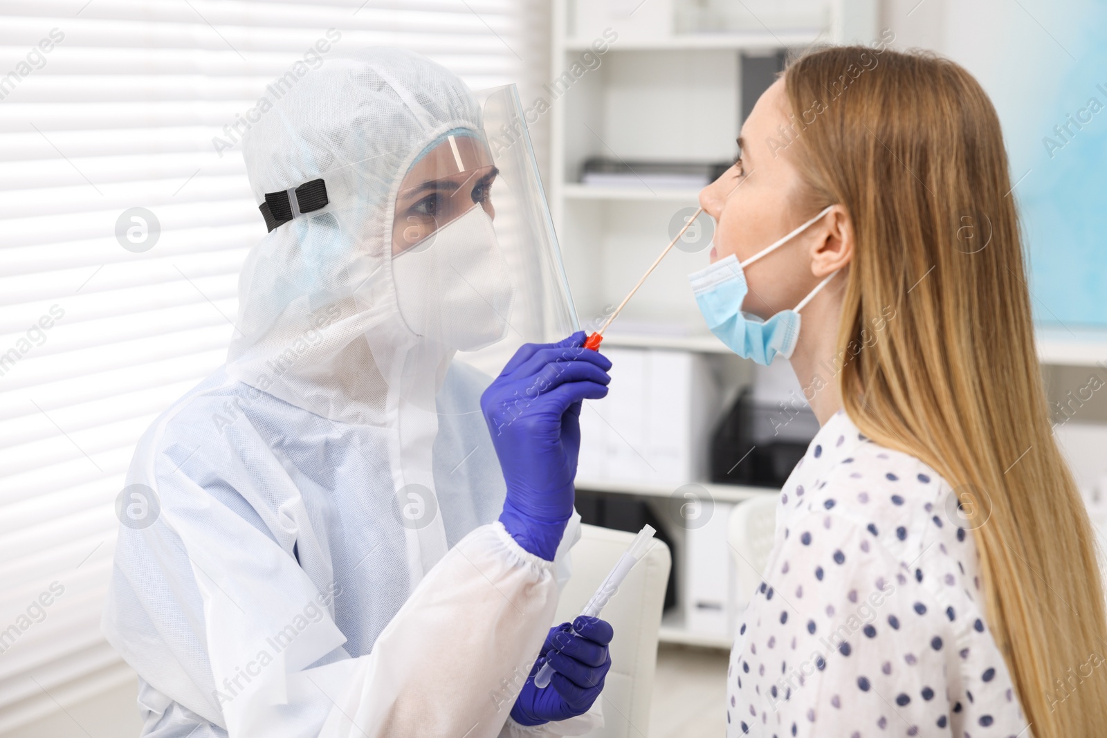 Photo of Laboratory testing. Doctor in uniform taking sample from patient's nose with cotton swab at hospital