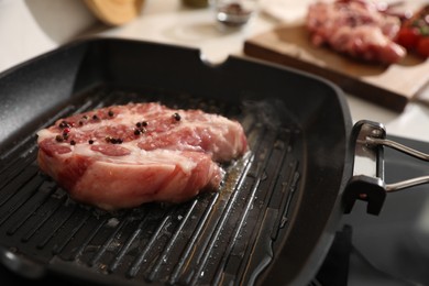 Photo of Frying pan with fresh raw meat on stove