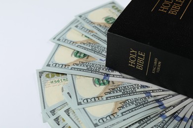 Photo of Holy Bible with money on white background, closeup