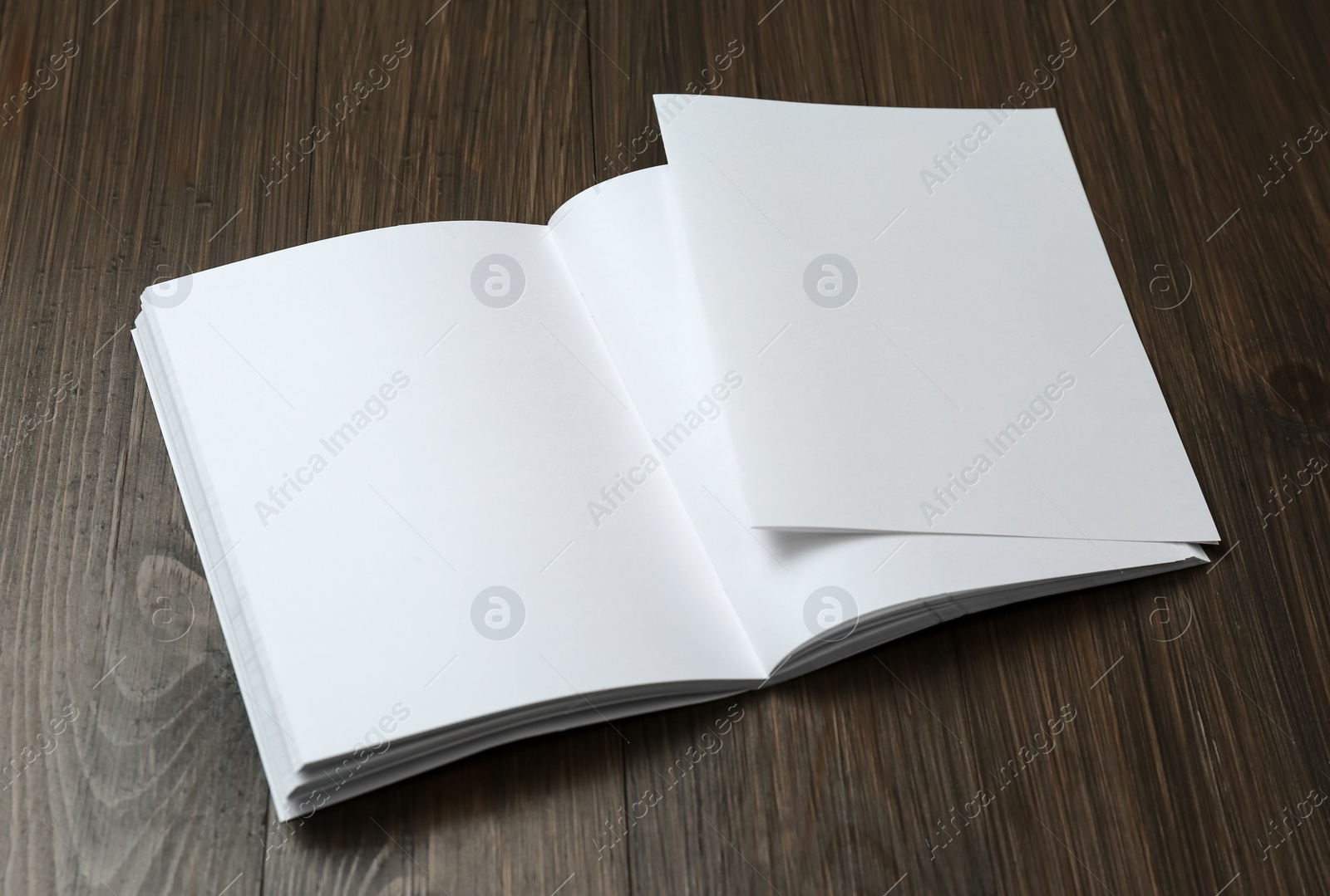 Photo of Sheet of paper and blank brochure on wooden table. Mockup for design