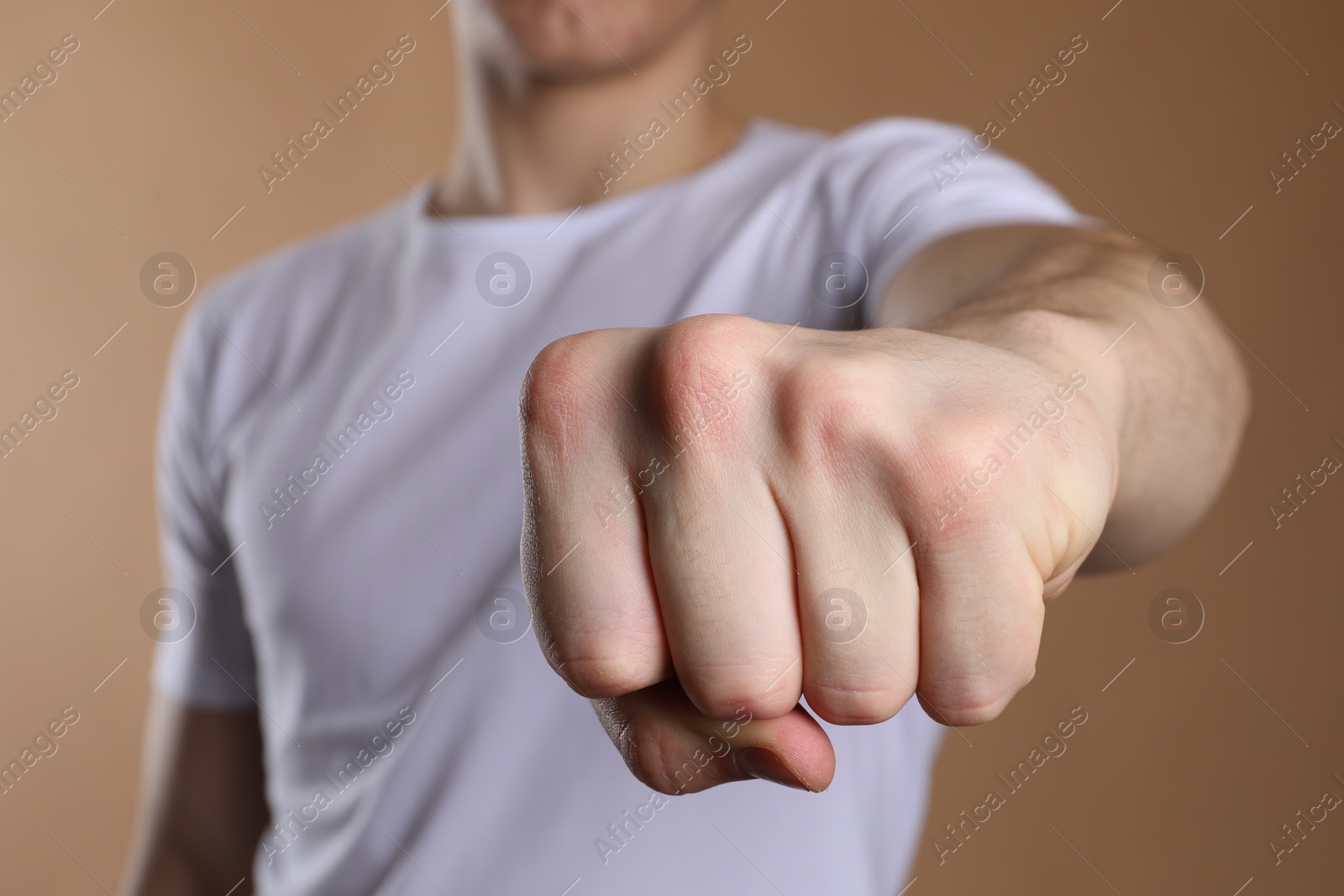 Photo of Man showing fist with space for tattoo on beige background, selective focus