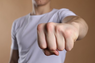 Man showing fist with space for tattoo on beige background, selective focus