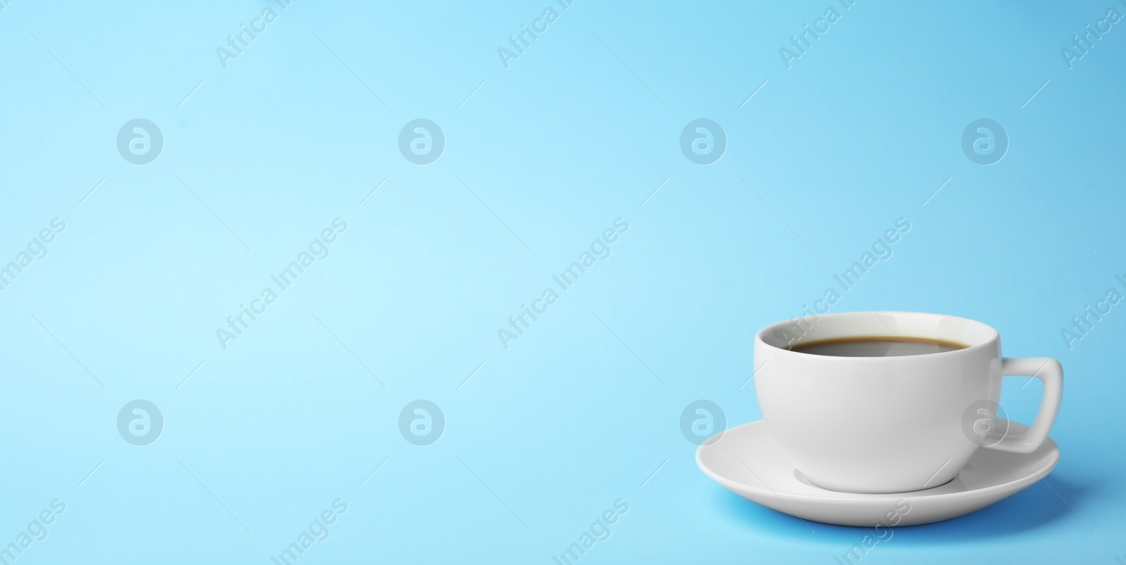 Photo of White ceramic cup with hot aromatic coffee on color background