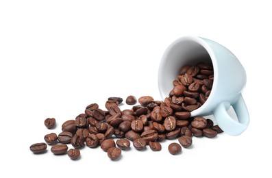 Photo of Overturned cup and roasted coffee beans on white background