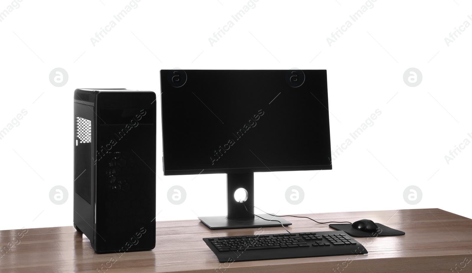 Photo of Modern computer with blank monitor screen and peripherals on wooden table against white background