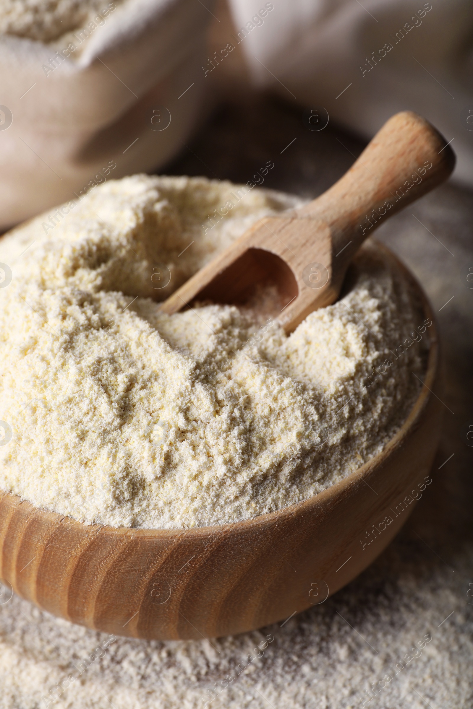 Photo of Wooden bowl with quinoa flour and scoop on table