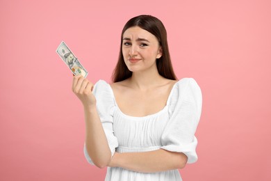 Photo of Sad woman with dollar banknote on pink background